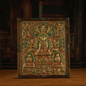 1 RADIANCE OF COMPASSION – 19TH CENTURY GILT COPPER JOWO BUDDHA WALL THANGKA